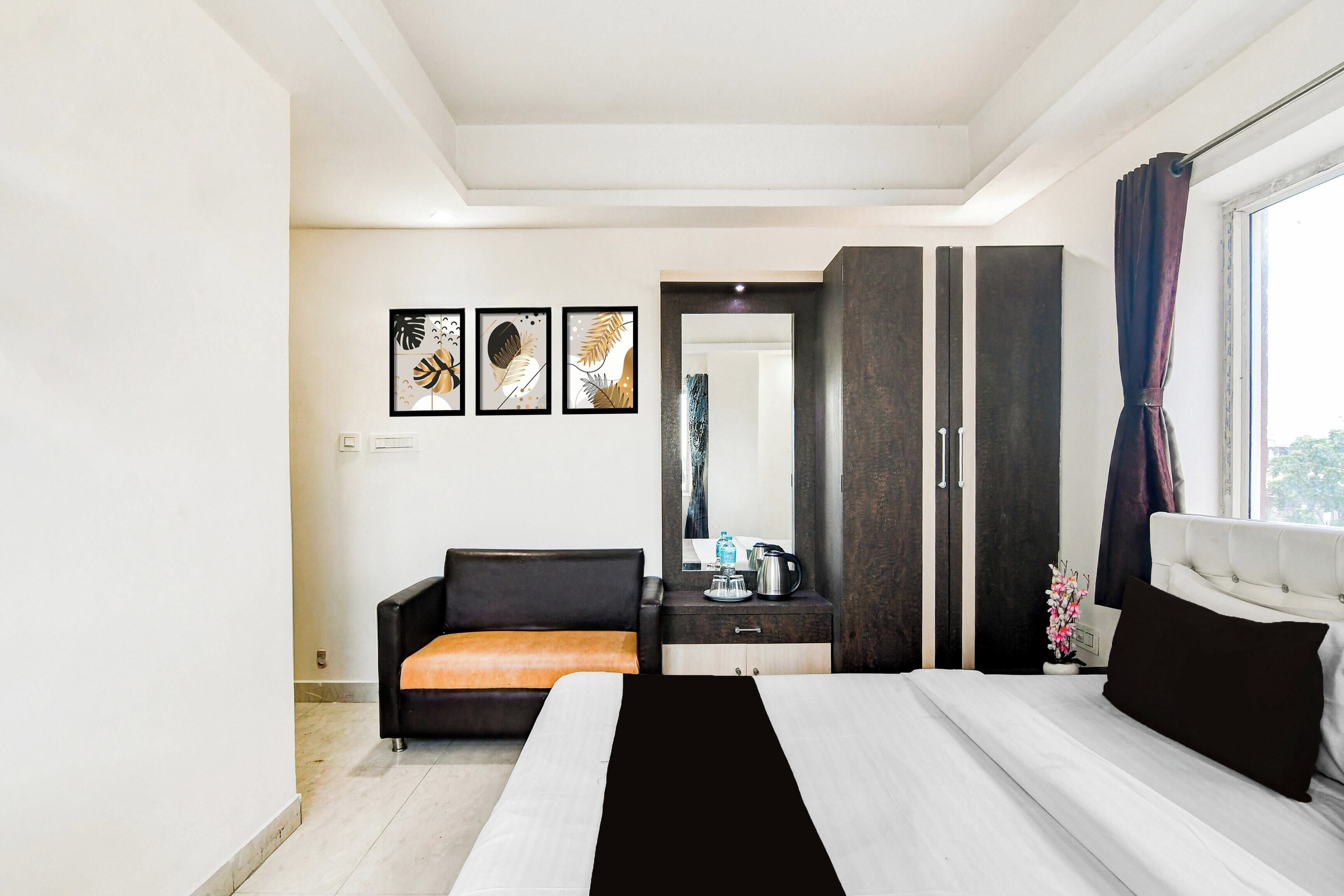 Een moderne hotelkamer met een bed, een slaapbank, een bureau en een kledingkast.