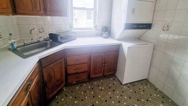 A compact kitchen with a sink, cabinets, a refrigerator, and a window. - Inviting 1BR Apartment — Rockledge Location (Rockledge)