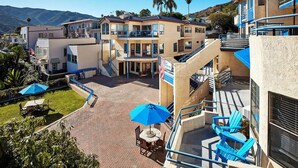 A hotel with multiple floors, outdoor seating areas, and a view of the mountains. - 2 Units | Seaport Village Stay Avalon Waterfront Views (Avalon)