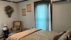 A hotel room with a large bed, a chair, a lamp, and a window with curtains. - Grand Victorian - Easy GAP Access, shops, and restaurants (Confluence)