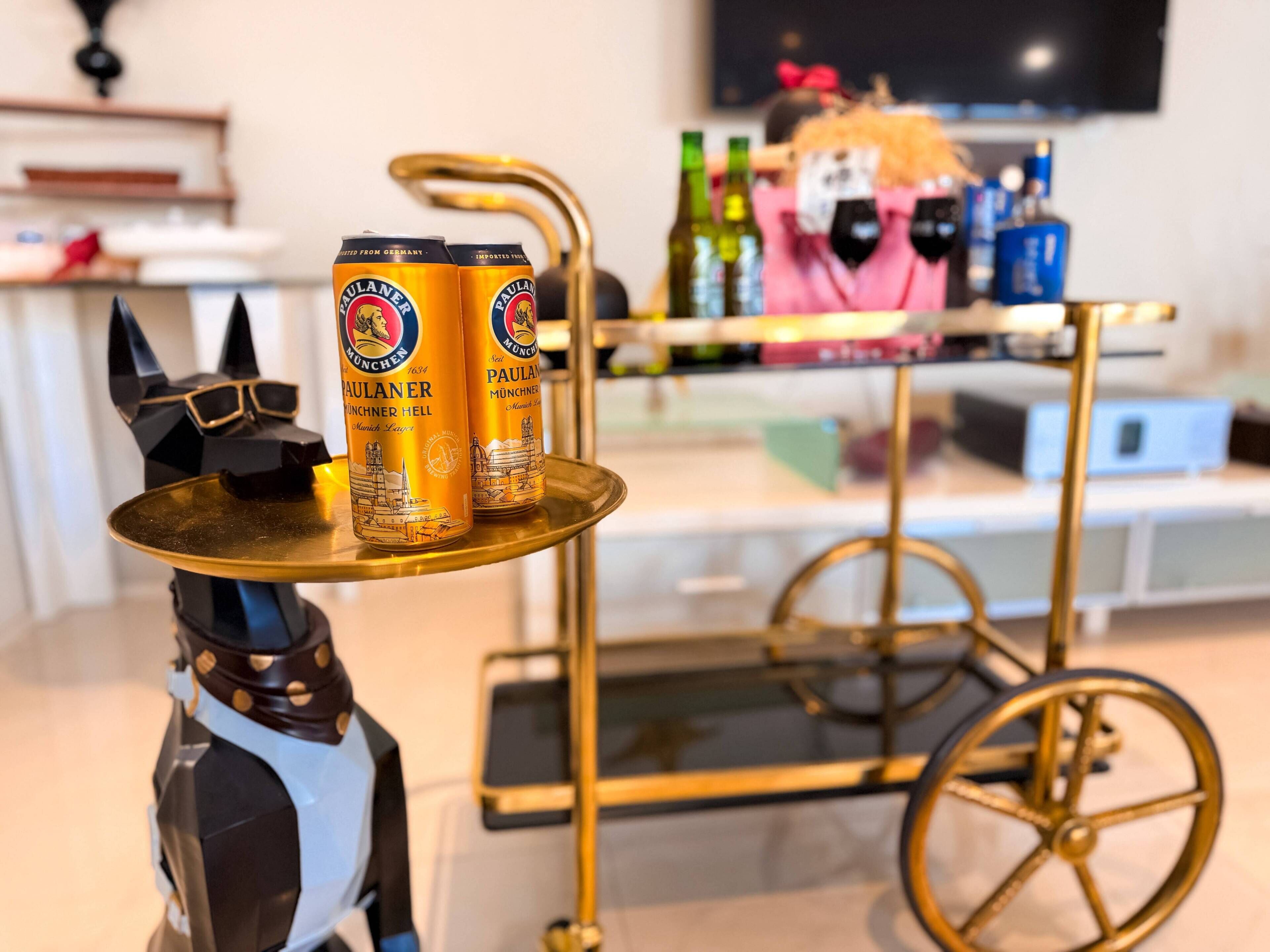 Een tafel met twee blikjes bier en een decoratief object dat op een pinguïn lijkt.