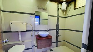 A small bathroom with a toilet, a sink, and a shower. - Hotel Meet Residency (Ahmedabad)