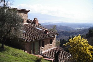 Un bâtiment en pierre avec un toit en pente, une petite fenêtre et une porte.