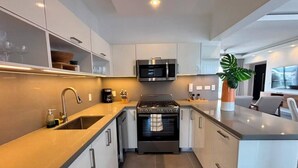 Una cocina moderna con horno empotrado, microondas y electrodomésticos de acero inoxidable.