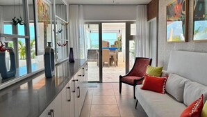 Un interior moderno con cocina, comedor y un sofá con cojines de colores.