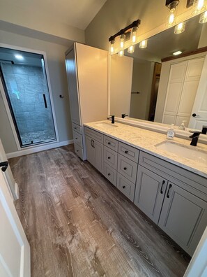 A bathroom with a large mirror, a double sink, and wooden flooring. - Beautiful 3 Bedroom/2.5 bath Condo Steps from Downtown Winter Park (Winter Park)