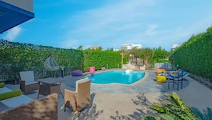A swimming pool with lounge chairs and a pergola, surrounded by greenery. - Spacious villa with private pool (Red Sea Governorate)