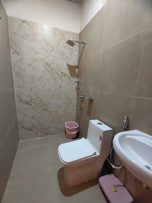 A bathroom with a toilet, bidet, and shower. - SHRI KHATUSHYAM RESIDENCY (Varanasi)