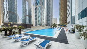 A rooftop pool with lounge chairs, surrounded by high-rise buildings. - Free Housekeeping Visits During Your Stay - Stayshort - Bright 1 Bedroom Retreat in Dubai Marina That Sleeps 2 (Dubai)