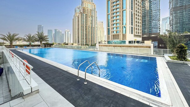 A rooftop swimming pool with a view of high-rise buildings. - Free Housekeeping Visits During Your Stay - Stayshort - Bright 1 Bedroom Retreat in Dubai Marina That Sleeps 2 (Dubai)