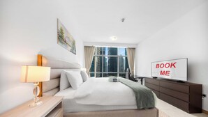 A modern hotel room with a bed, bedside table, lamp, TV, and a view of the cityscape. - Free Housekeeping Visits During Your Stay - Stayshort - Bright 1 Bedroom Retreat in Dubai Marina That Sleeps 2 (Dubai)