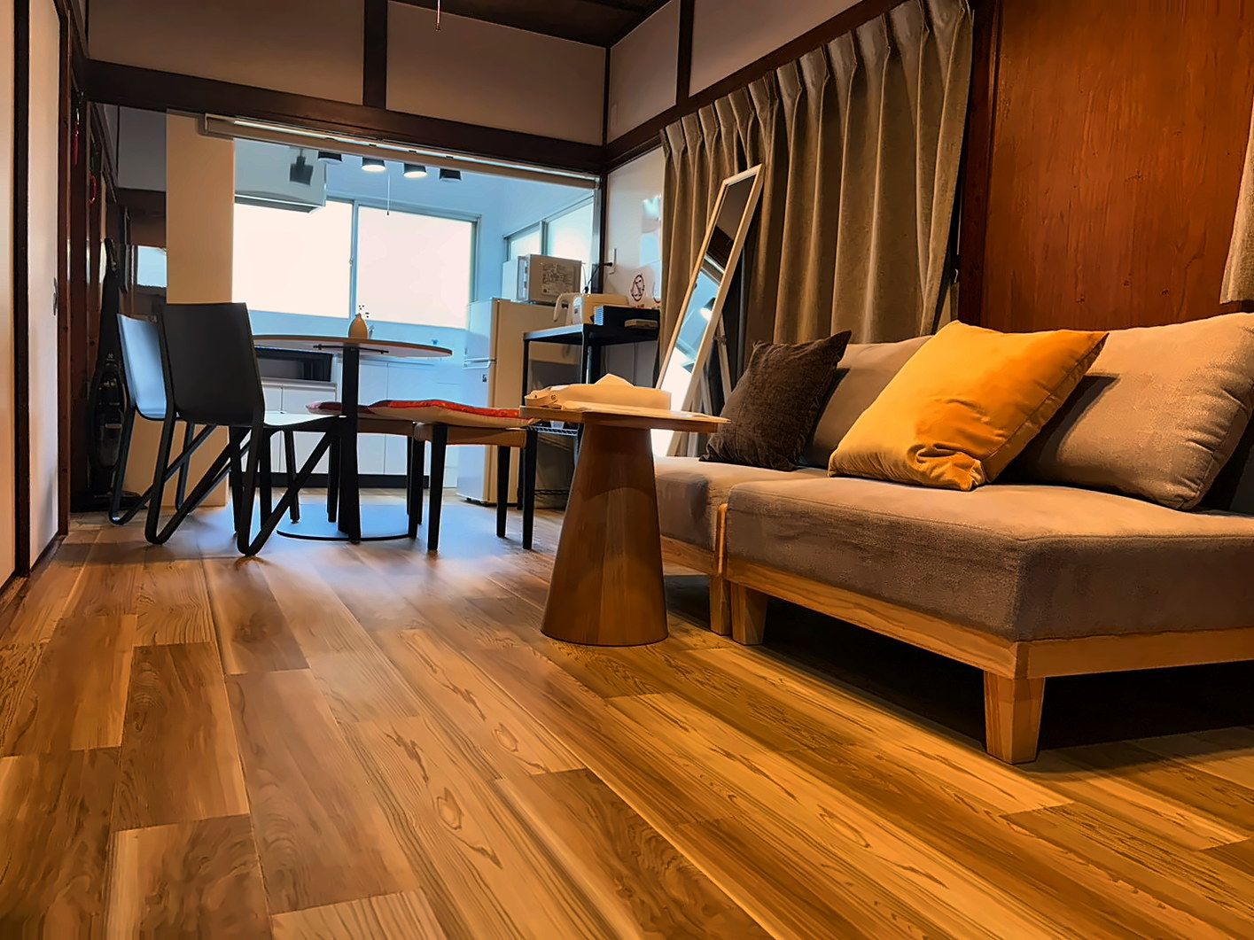 A modern living room with a sofa, a coffee table, and a dining area with chairs.