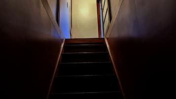 A staircase leading to a door with a light switch above it.