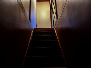 A staircase leading to a door with a light switch above it. - MSTAY Oshiage One (Sumida-ku)
