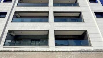 A multi-story building with a grid of windows and balconies.