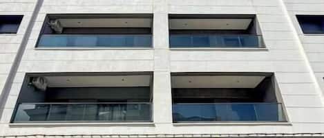 A multi-story building with a grid of windows and balconies.