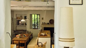 A cozy kitchen with a dining area, a large lamp, and a framed picture on the wall. - Luxury 6BR House in Eygalières Provence - Hotel Services, Pool, Sauna (Eygalières)
