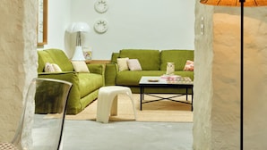 A living room with a green sofa, a coffee table, a lamp, and a chair. - Luxury 6BR House in Eygalières Provence - Hotel Services, Pool, Sauna (Eygalières)