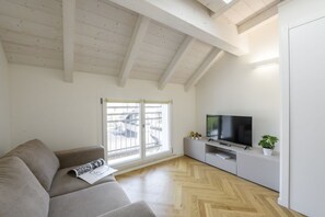 A modern living room with a sofa, TV, and a large window. - NOVARA, 62 – Sky Loft Milan (Milano)