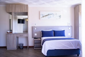 A modern bedroom with a bed, bedside table, and a built-in TV.