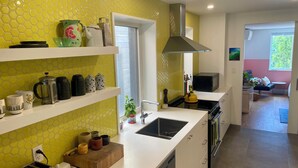Una cucina moderna con un piano di lavoro bianco, una lavastoviglie integrata e una cappa aspirante in acciaio inossidabile.