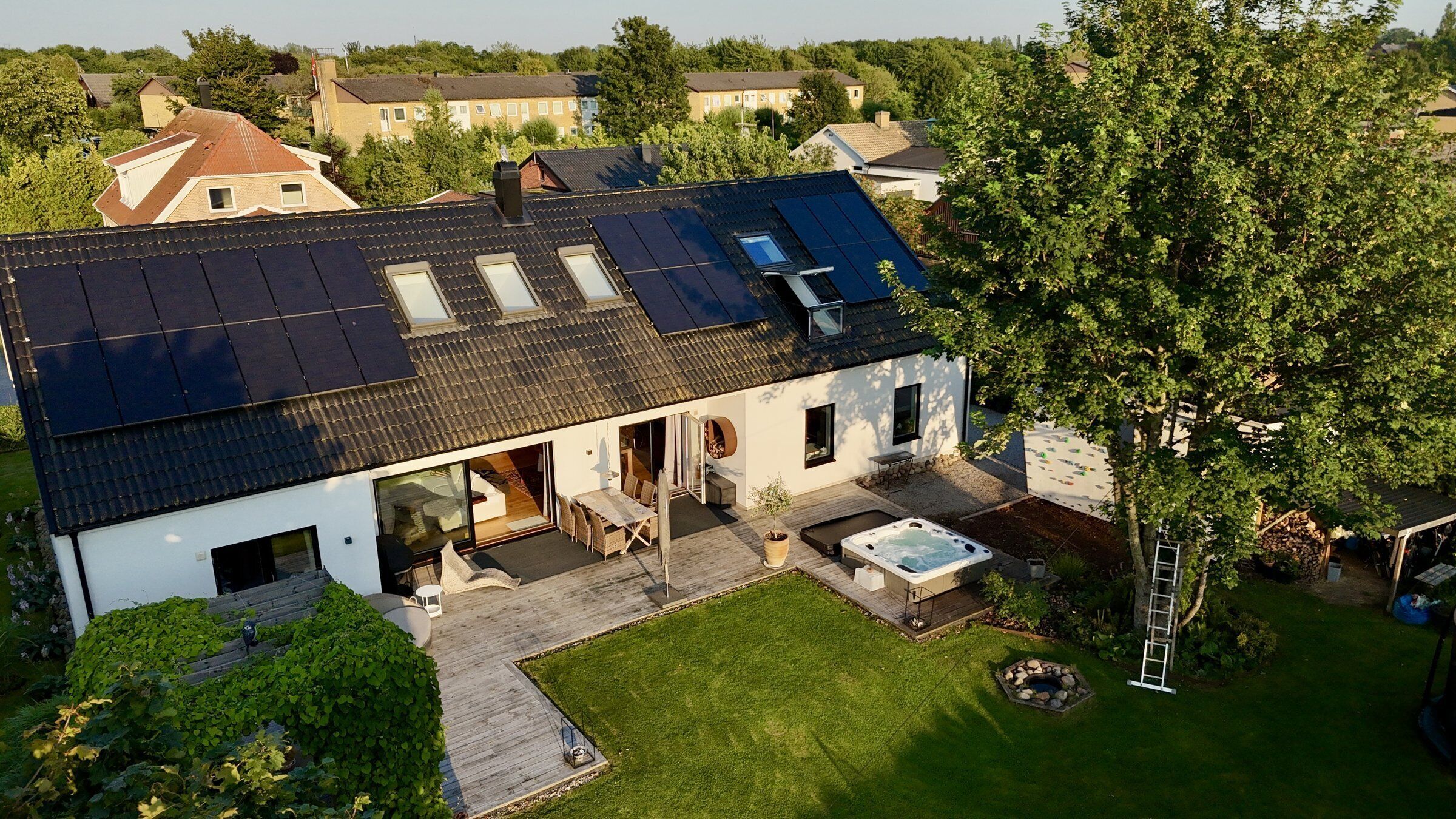 A house with a sloped roof, a hot tub, and a well-maintained lawn.