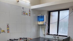 A kitchen with a gas stove, sink, and a water dispenser.