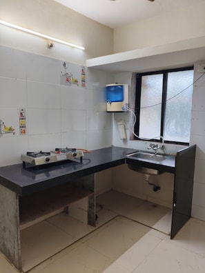 A kitchen with a gas stove, sink, and a water dispenser.