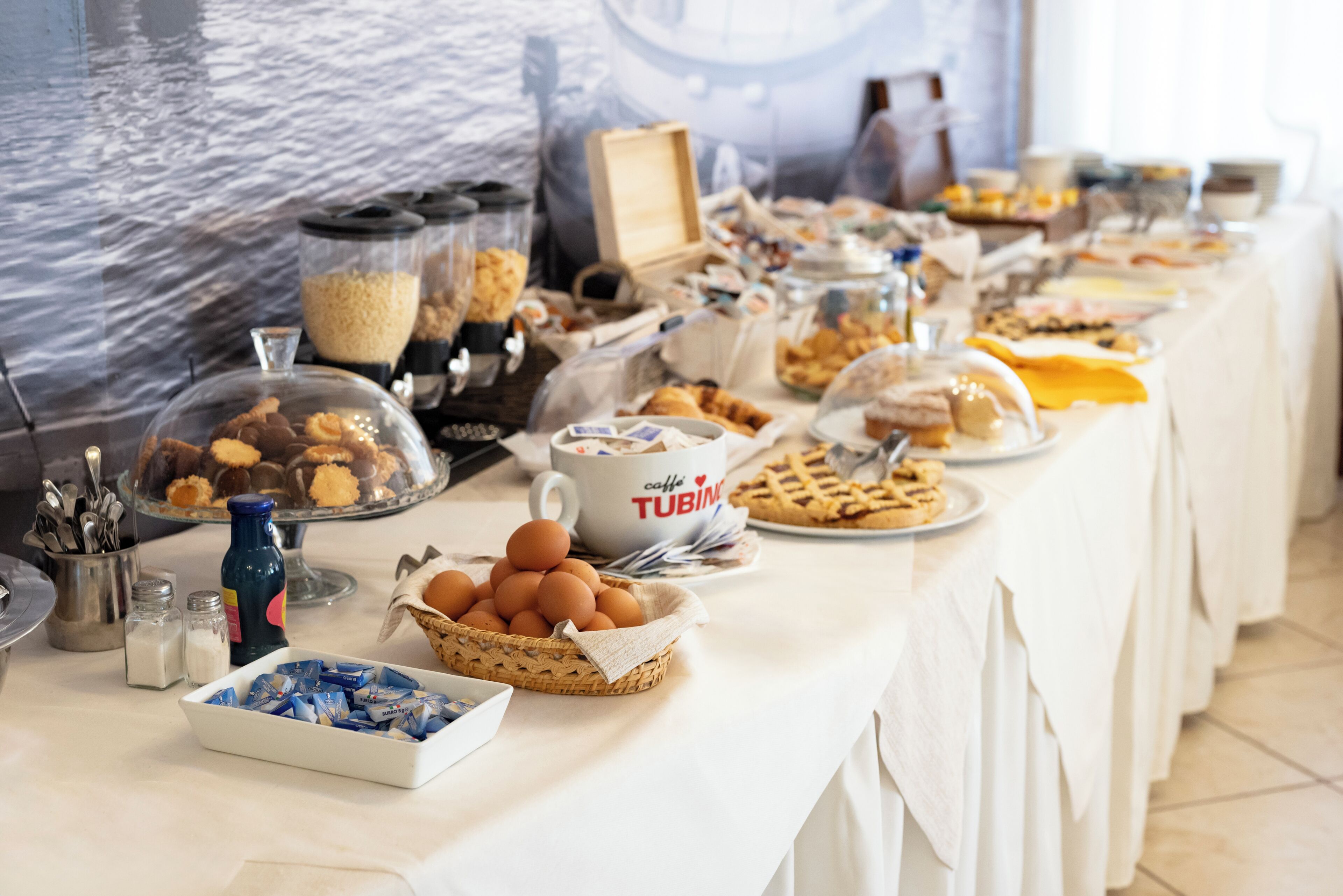 Una mesa de buffet con diferentes alimentos y una taza de café.
