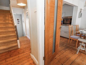 A wooden staircase leading to a room with a kitchen area, including a dining table and chairs. - Driftmark (Weymouth)