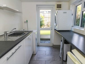 A compact kitchen with a sink, a dishwasher, and a built-in oven. - Driftmark (Weymouth)