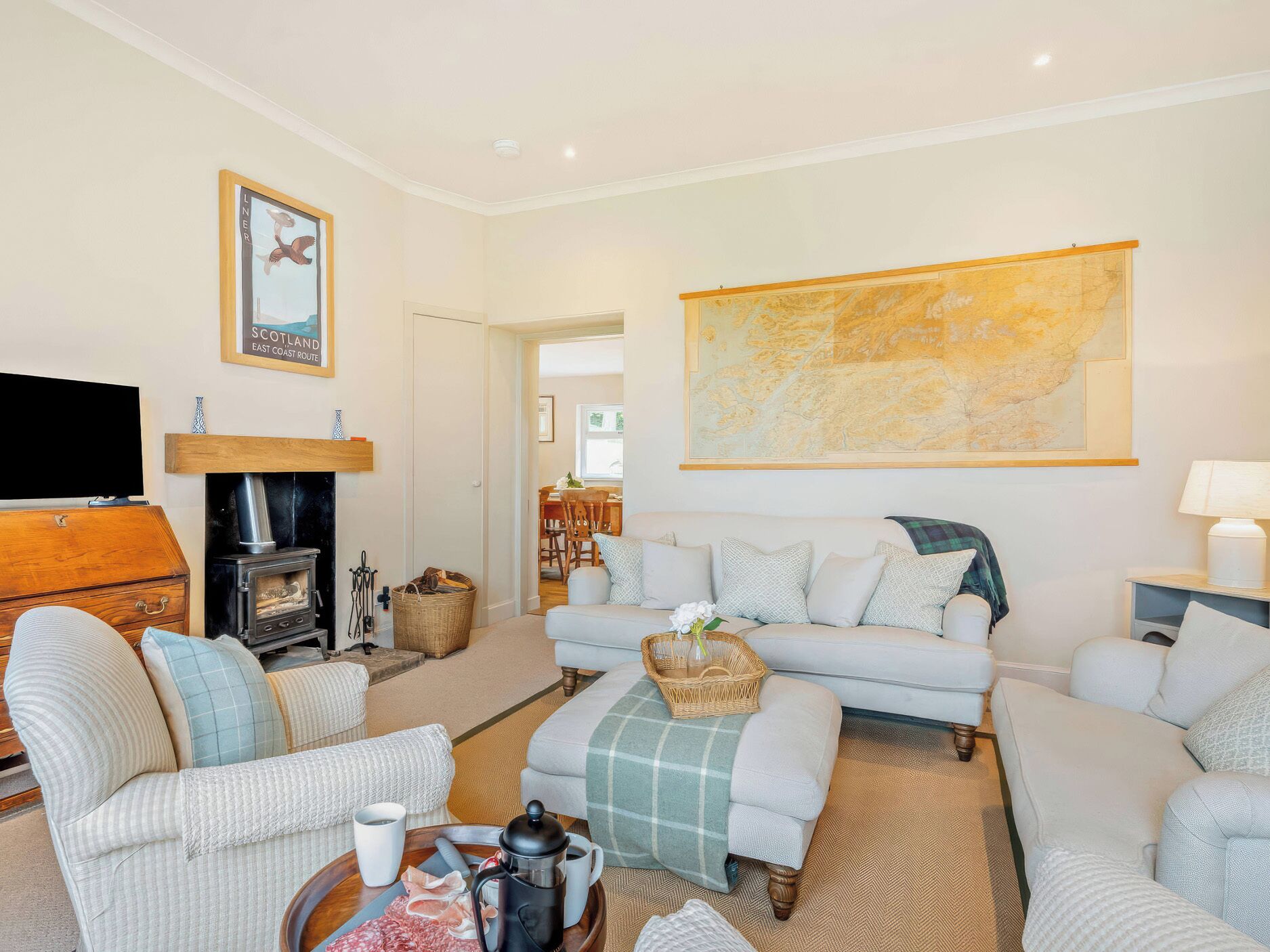 A cozy living room with a fireplace, comfortable seating, and a large map on the wall.