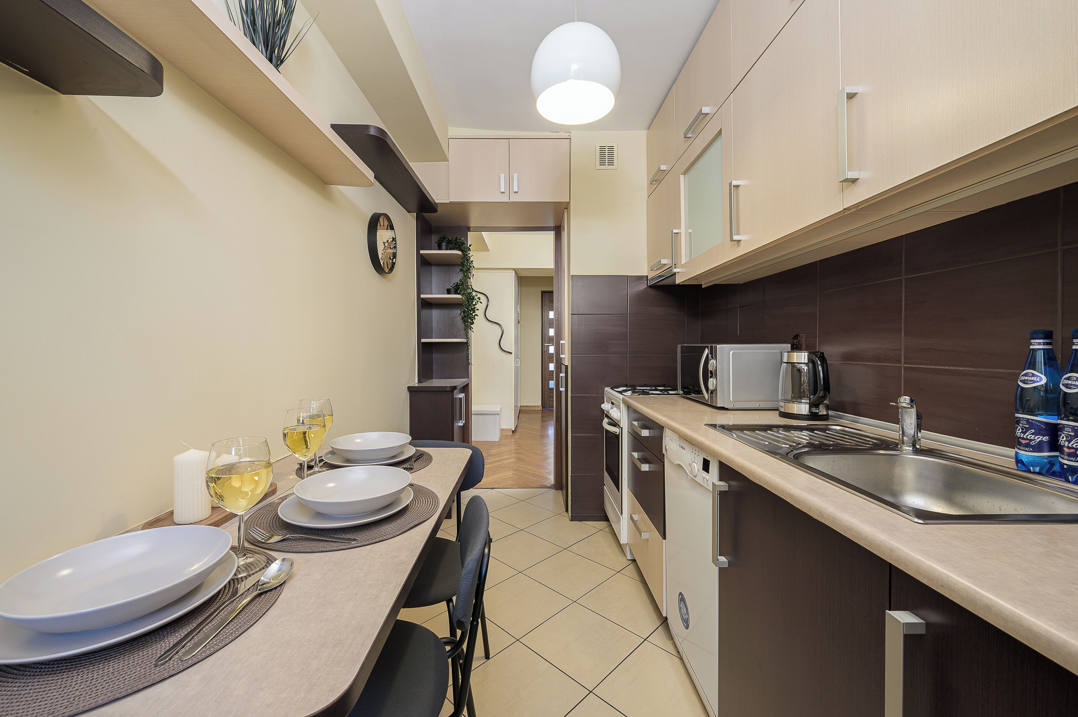 Cocina compacta con comedor, equipada con electrodomésticos modernos y una mesa para dos.
