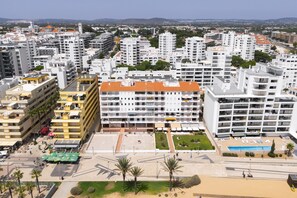 A high-rise hotel with multiple floors, a rooftop pool, and a landscaped courtyard. - Gira Sol by Hdproperties (Quarteira)