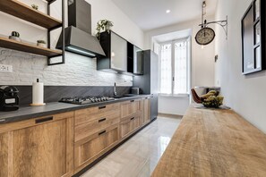 Eine moderne Küche mit Marmor-Spritzschutz, Holzschränken und einer Edelstahl-Dunstabzugshaube.