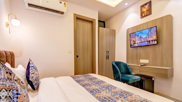 A hotel room with a bed, a desk, a chair, a television, and a wardrobe. - Golden Key - Adarsh Nagar I Near Maxx & Fortis Hospital (New Delhi)