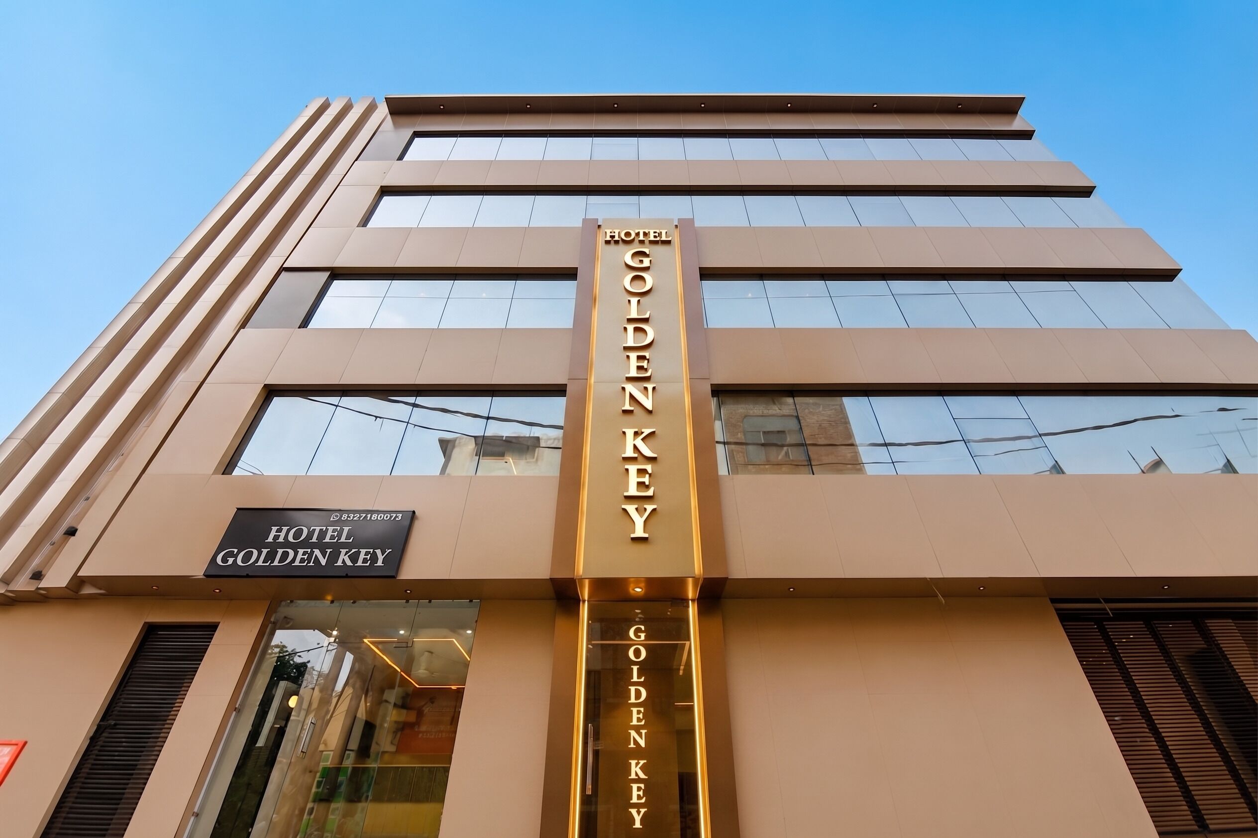 Un edifici d'hotel modern amb un prominent cartell que diu 'HOTEL GOLDEN KEY'.