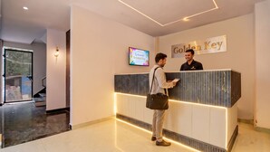 A reception desk with a 'Golden Key' sign, a digital welcome screen, and a modern interior design. - Golden Key - Adarsh Nagar I Near Maxx & Fortis Hospital (New Delhi)