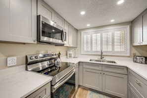 A modern kitchen with stainless steel appliances, a built-in oven, a microwave, a coffee maker, and a toaster. - Majestic Gulf Views Condo w/ Balcony (Clearwater Beach)