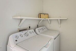 A front-loading washer and dryer unit with control knobs and a water level indicator. - Fenced Yard! Austin Group Escape Near Golf (Austin)