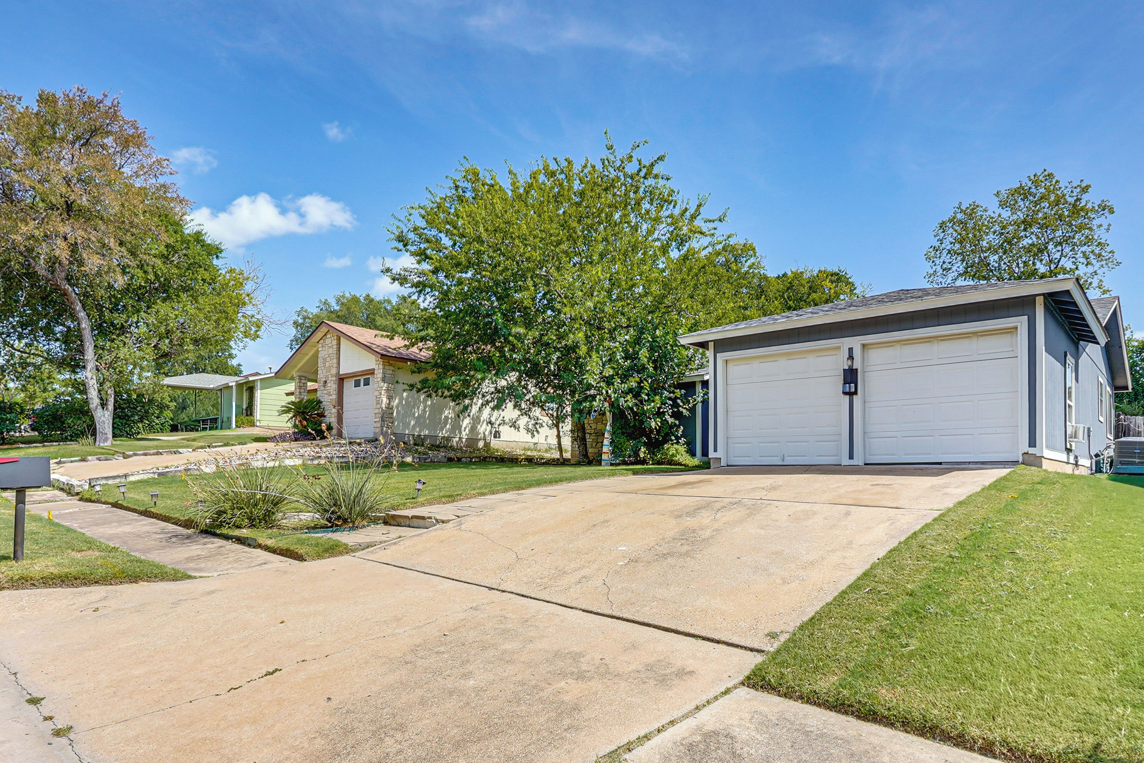 A residential driveway leading to a garage with a house in the background.