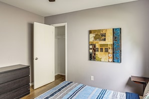 A bedroom with a bed, a dresser, a closet, and a wall-mounted artwork. - Fenced Yard! Austin Group Escape Near Golf (Austin)