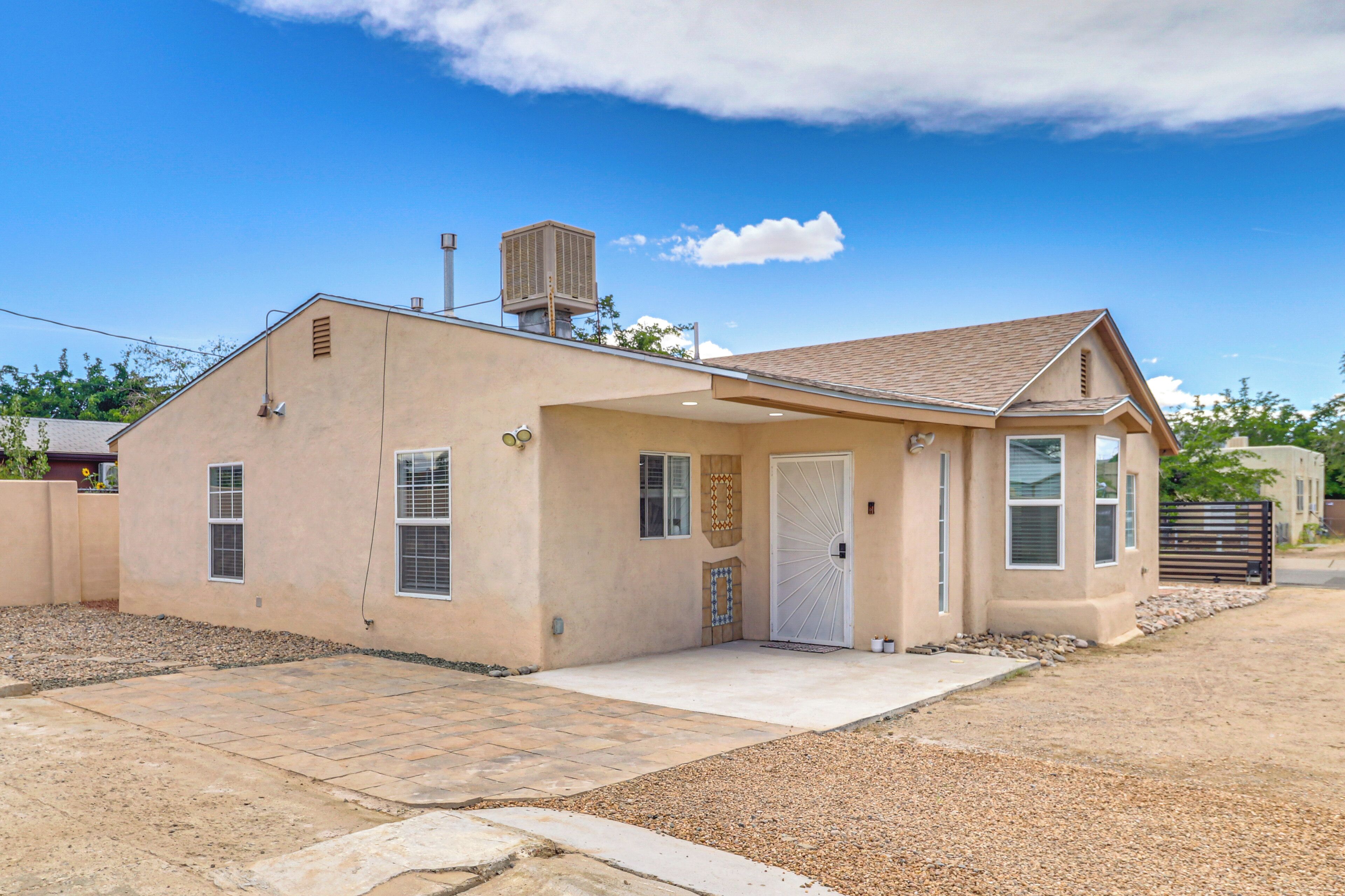 A single-story house with a beige exterior, a front door, and a small porch area.