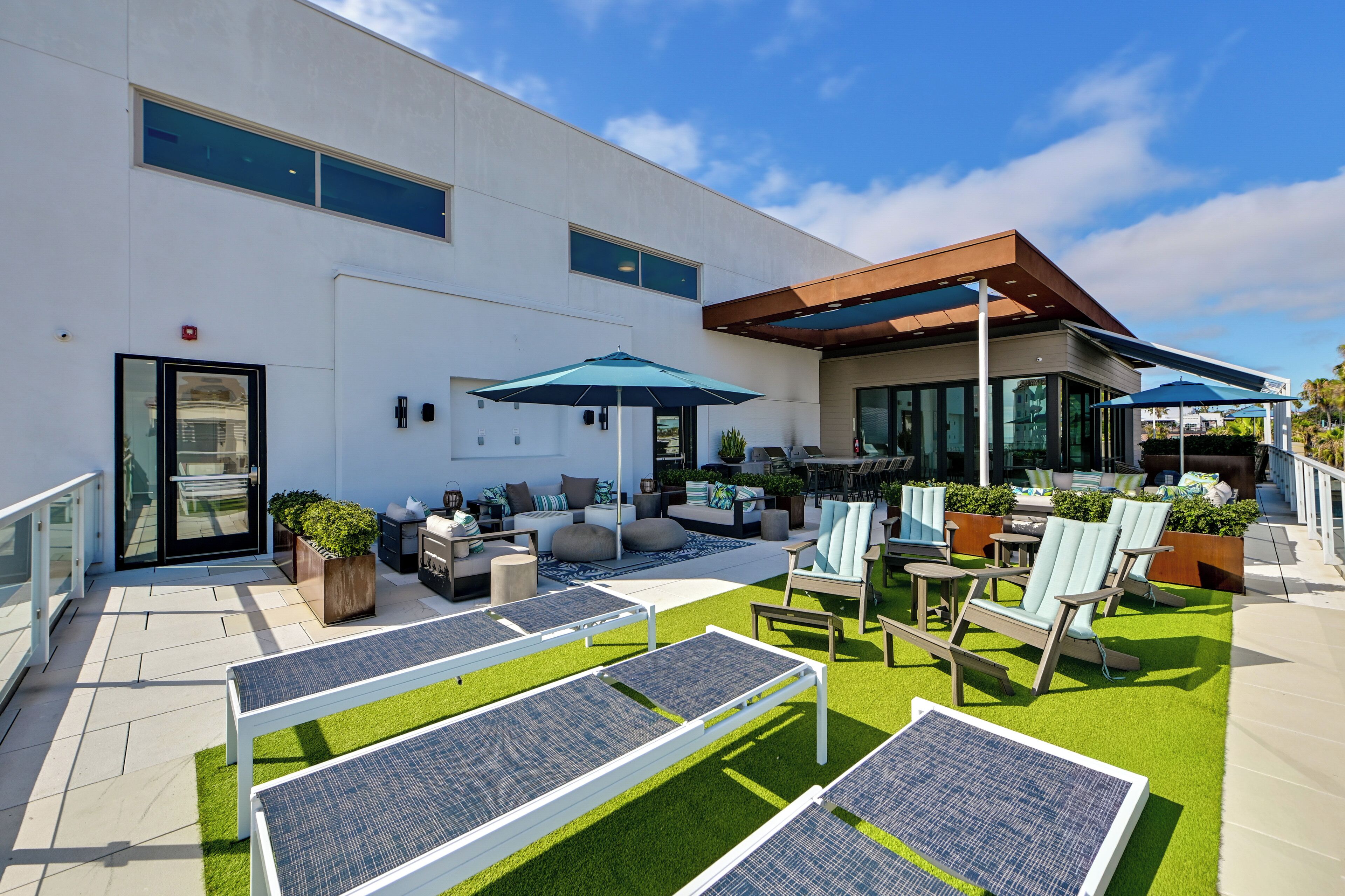 A modern outdoor patio with seating, solar panels, and a covered area.