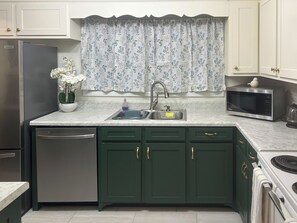 A kitchen with a dishwasher, sink, microwave, and stove. - Golf & Chill! Family-friendly Augusta Home (Augusta)