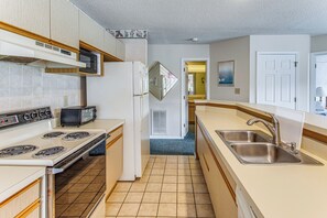 A kitchen with a stove, microwave, toaster, refrigerator, and sink. - Lake-view Balcony, Pool Access! Sunset Beach Condo (Sunset Beach)