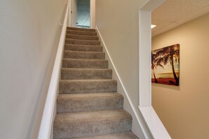 A carpeted staircase with white handrails leading to a room with a beach scene painting on the wall. - Private Patio, Yard! Townhome Near Pensacola Beach (Gulf Breeze)