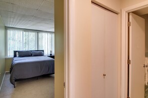 A bedroom with a bed, a window with blinds, and a door. - Private Patio, Yard! Townhome Near Pensacola Beach (Gulf Breeze)