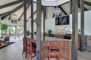 A restaurant with a bar area, wooden chairs, and a large window. - Private Patio, Yard! Townhome Near Pensacola Beach (Gulf Breeze)