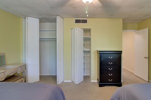 Een slaapkamer met een bed, een dressoir, een kast en een bureau.